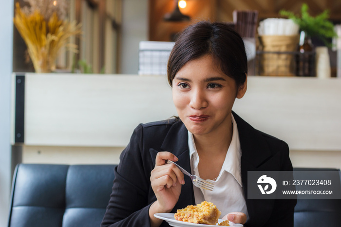 Asian business woman in relax time and eating apple pie in coffee shop. Hand holding  spoon used to eat pie. Apple pie, regional variation apple tart, which the principal filling ingredient is apple.