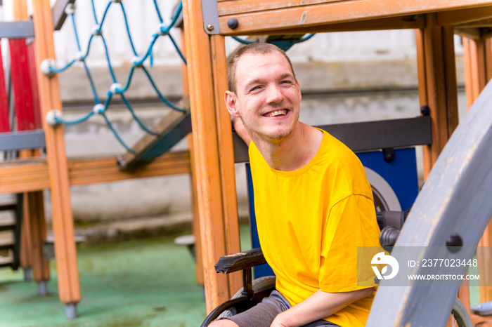 A disabled person in a wheelchair on the swings of a playground