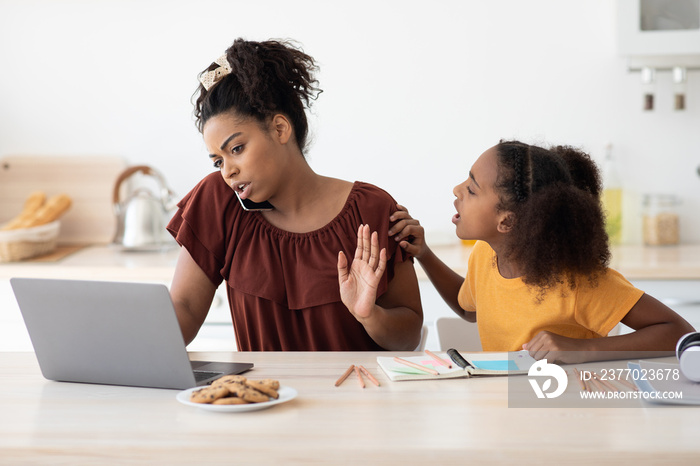 Angry teen girl sitting by working mom, kitchen interior