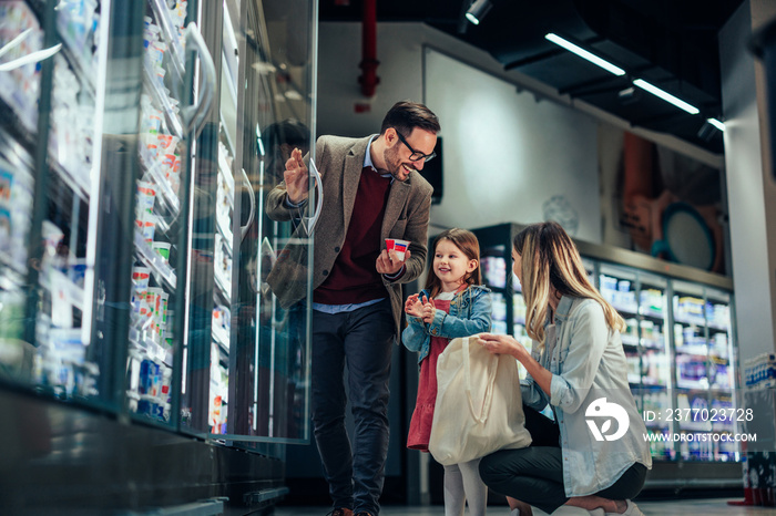 Parents and daughter shopping together in market