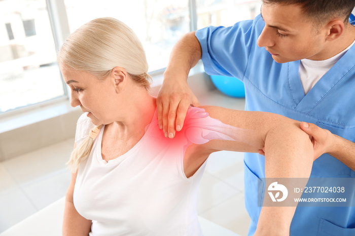 Physiotherapist working with mature patient in rehabilitation center