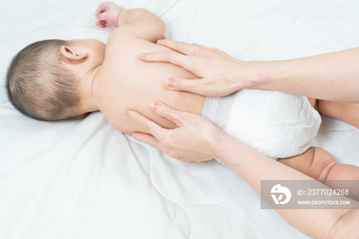 Cute baby massage back in bed, child and health concept.Baby massage and exercises.