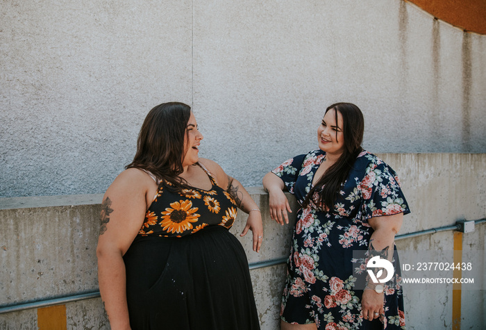 2 women stand around and talk