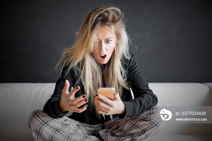 Frustrated woman looking at her phone