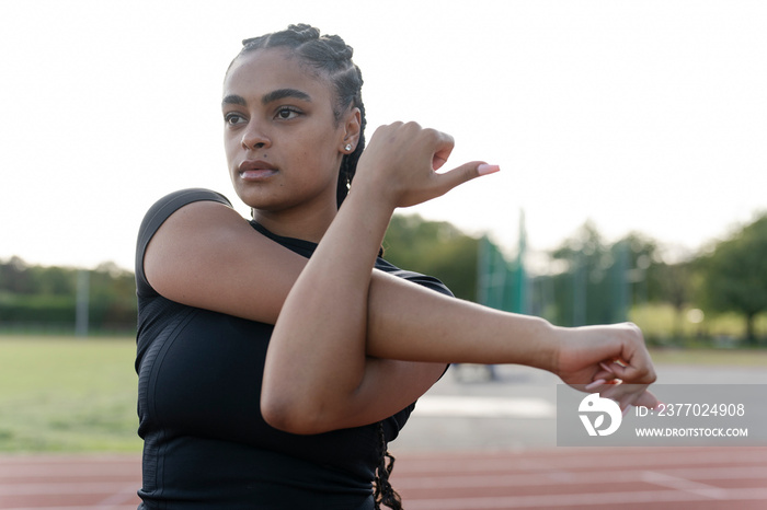 Female athlete stretching arms before training