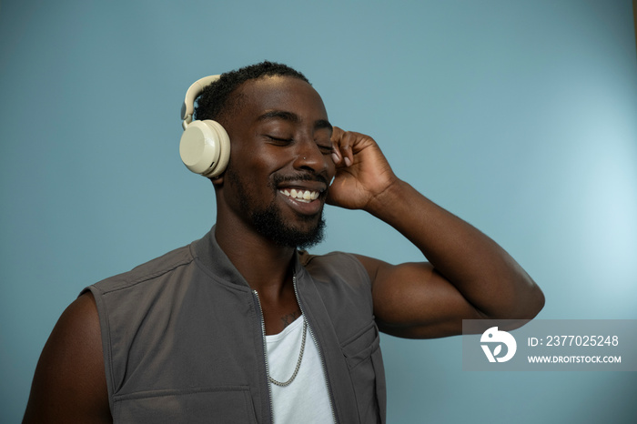 Smiling man wearing headphones and listening to music