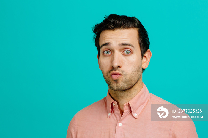 Portrait of a young man with raised eyebrows and pouted mouth