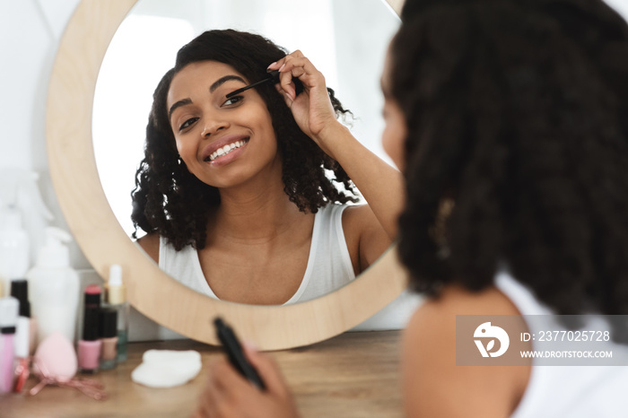 Daily Makeup. Beautiful Black Woman Applying Mascara On Eyelashes At Home