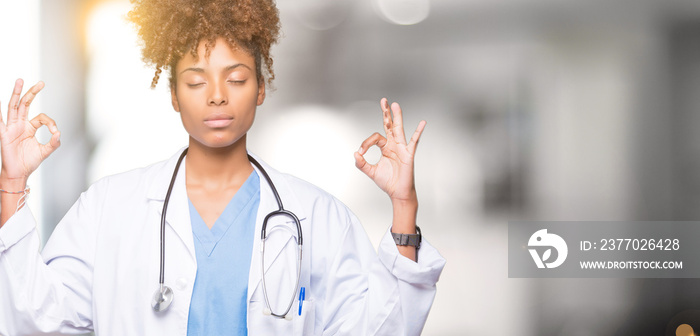 Young african american doctor woman over isolated background relax and smiling with eyes closed doing meditation gesture with fingers. Yoga concept.