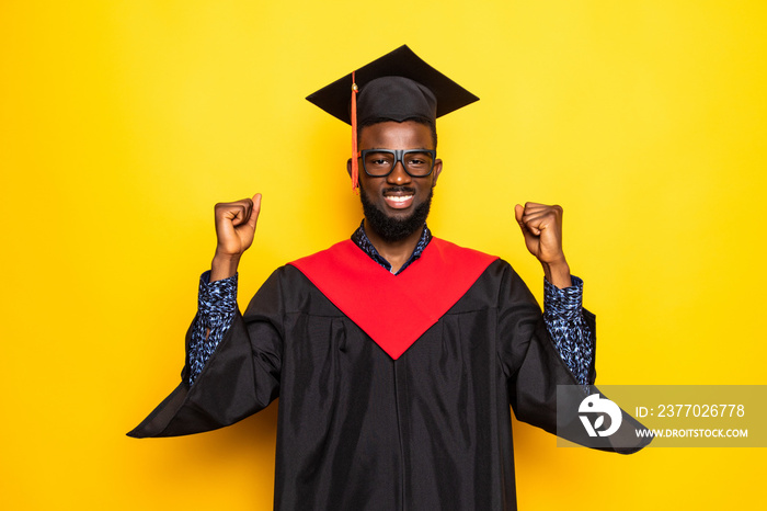 African American man college graduate with win gesture isolated on yellow background
