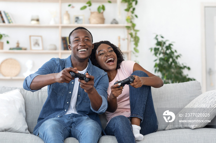 Emotional african family playing video games at living room