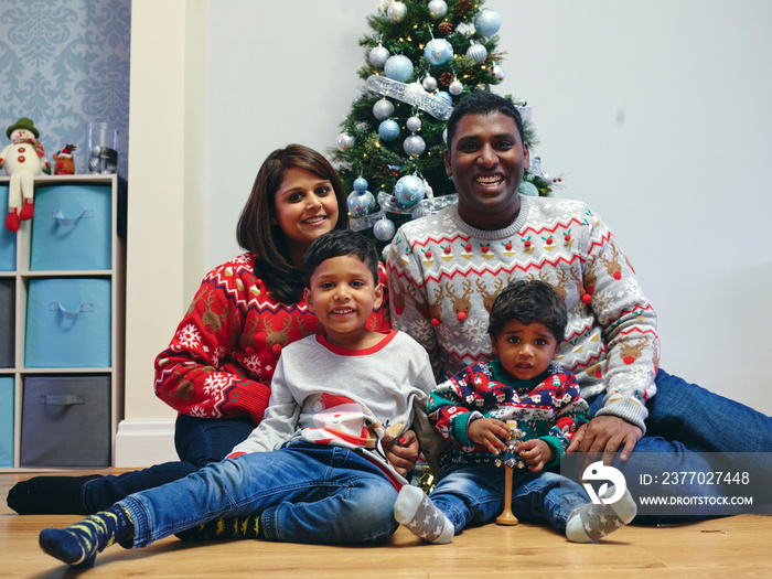 Portrait of family with sons in front of Christmas tree