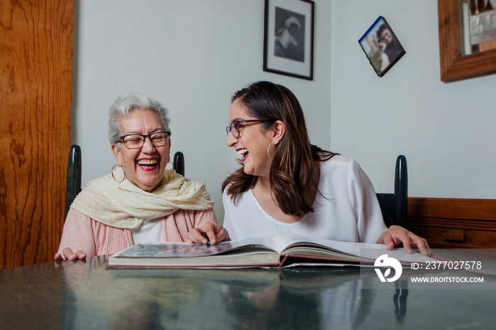 latin Grandmother and granddaughter sitting reading together book