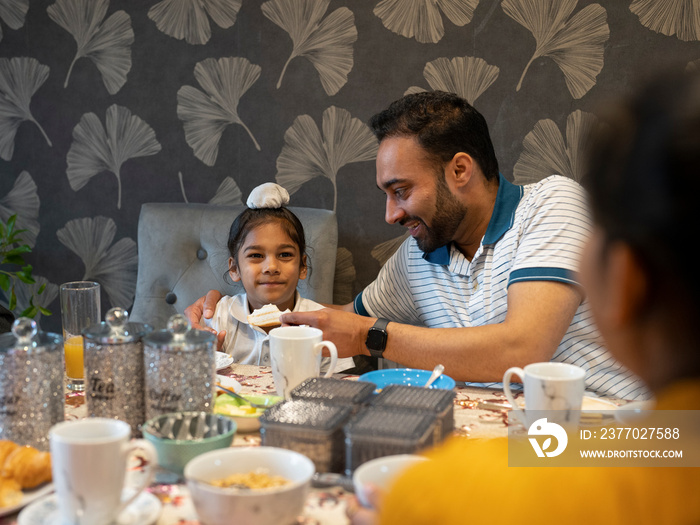 Father and son (6-7) eating meal at home