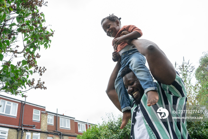 Father giving daughter (2-3) piggyback ride