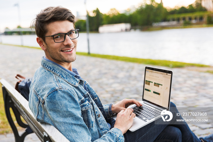 Handsome young man dressed casually spending time outdoors