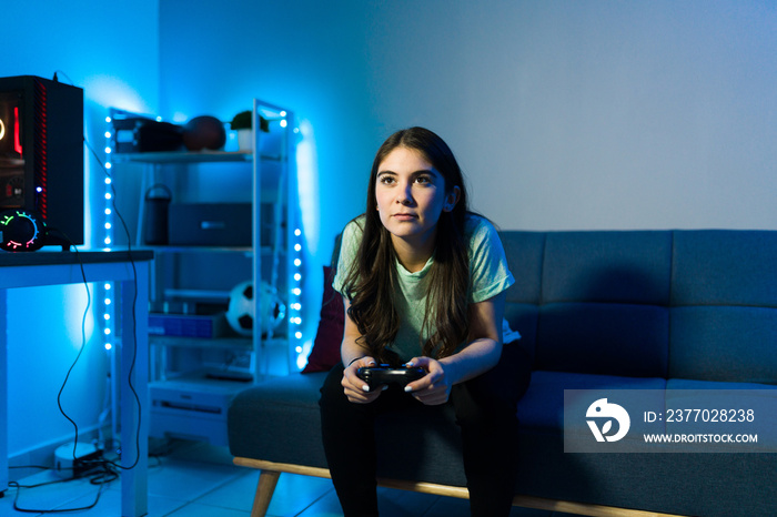 Beautiful woman gamer enjoying a videogame during a leisure day