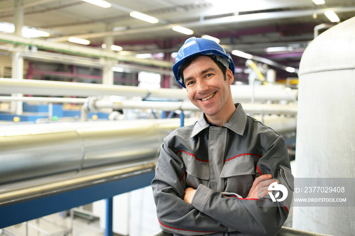 portrait of successful workman in an industrial company, in working clothes at the workplace  - closeup