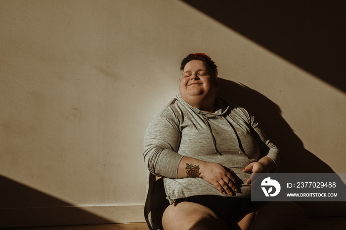 closeup portrait of a plus size woman face in the sun hands on belly