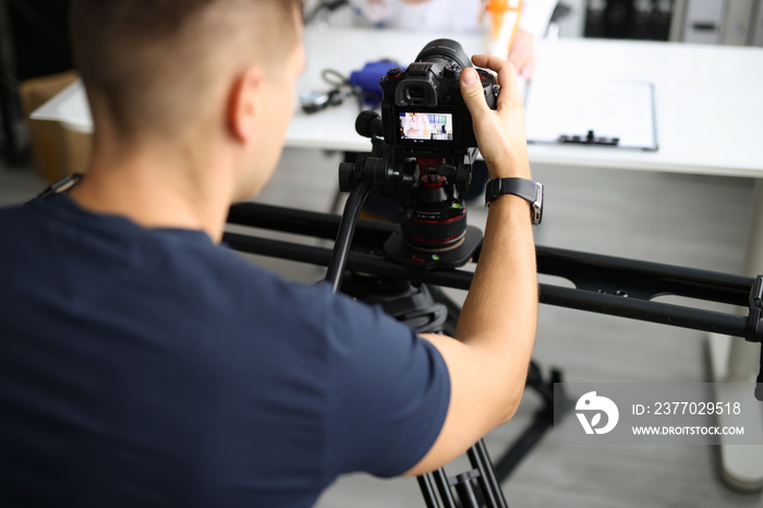 Blogger shooting video on professional camera in studio closeup