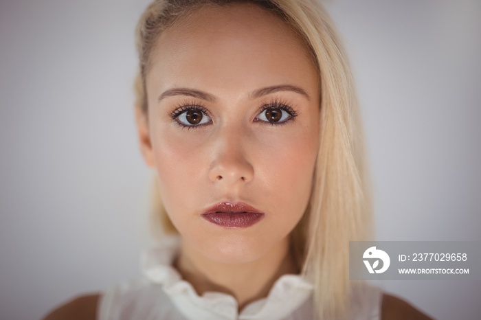 Portrait of confident businesswoman against wall in office