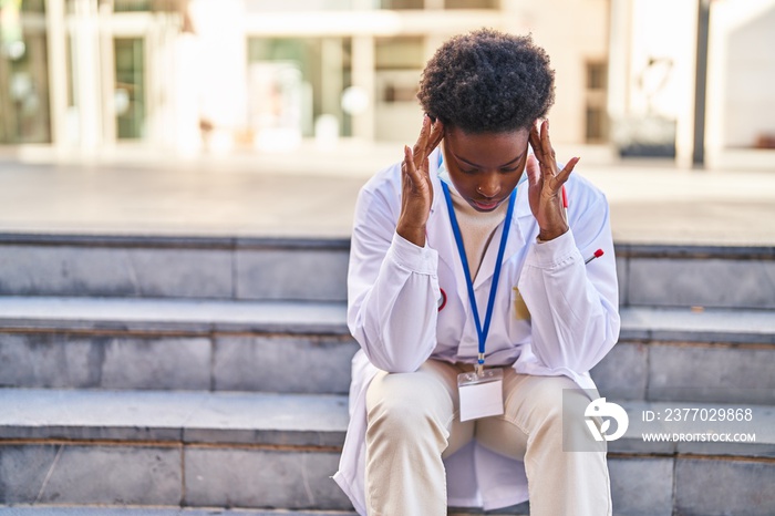 African american woman wearing doctor uniform and medical mask with worried expression at street