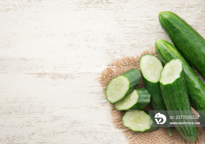 Cucumber and slices on wood background,top view