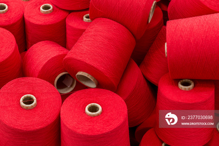 a large pile of spools of red thread. close up