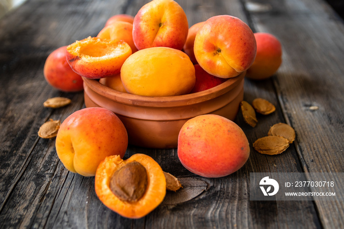 Fresh organic apricots in a clay bowl on old wooden table