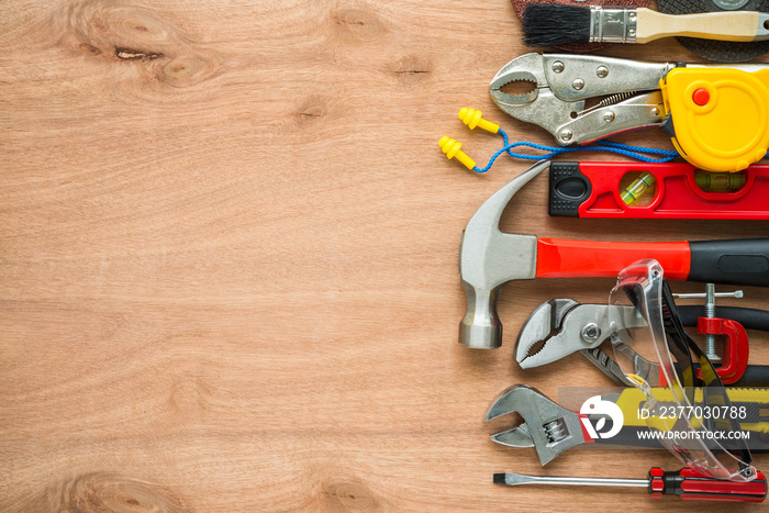 Flat lay, set of construction hardware tools building, repair, painting accessories on wooden board background