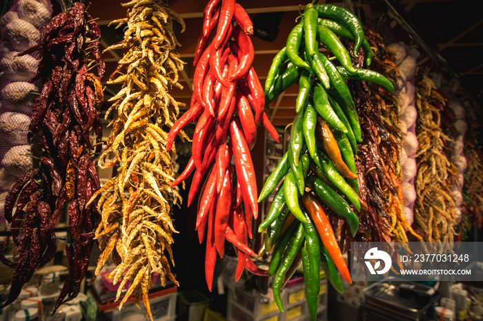 Dried red and green chili peppers hanging in Barcelona Market (Mercat de Sant Josep de la Boqueria) on the La Rambla street, Barcelona, Spain