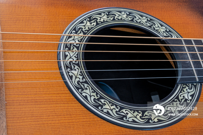 Selective focus  of acoustic six string guitar sound hole and Phosphor bronze strings