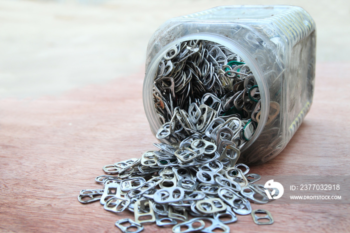 Rings pull opener aluminum in site plastic bottle on wooden background