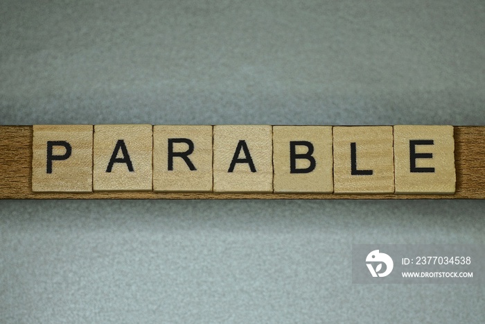 text the word parable from gray wooden small letters on an gray table