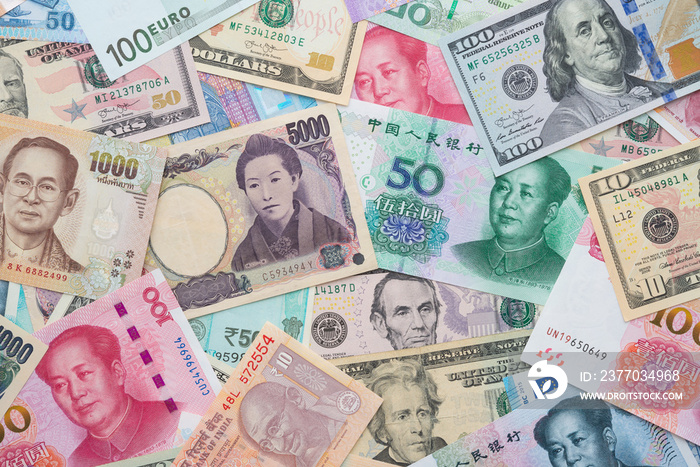 Flat lay or top view of world international banknotes vary countries background. US Dollar, Chinese yuan, Japanese yen, Euro, Indian rupee, Thai baht. Concept of Forex or global financial economic.