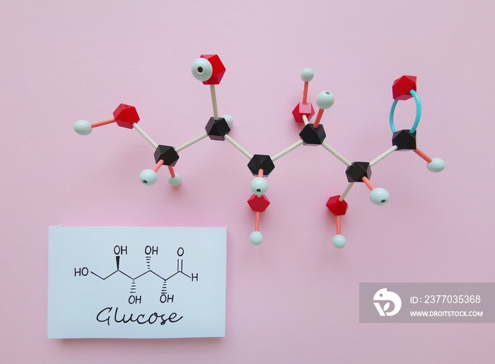 Molecular structure model and structural chemical formula of glucose molecule. D-Glucose (dextrose, blood sugar) is a simple sugar and it is the most abundant monosaccharide. Black=C, red=O, white=H.