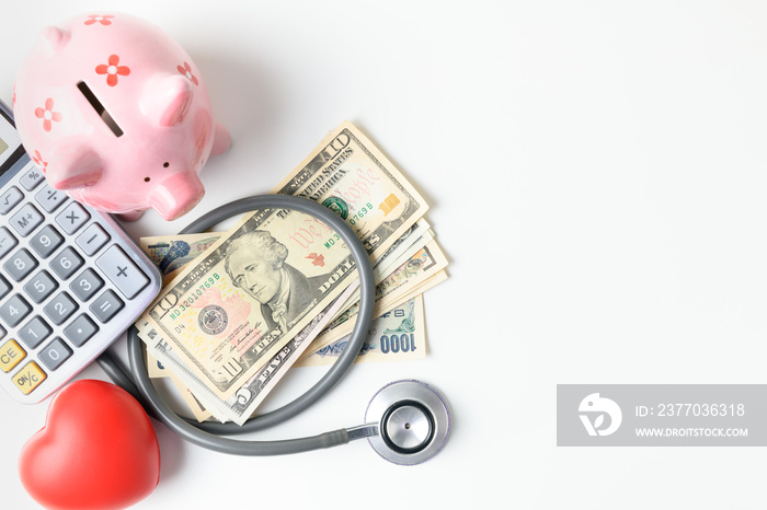 stethoscope on  banknote and piggy bank on white