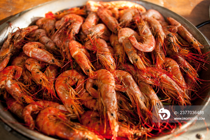 fried shrimp at a street food festival. shrimp on a large metal plate. Boiled shrimp on pan. fried in butter shrimp on pan.