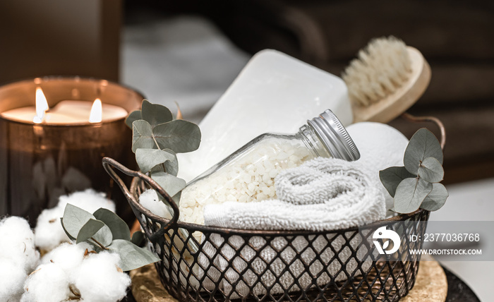 Cozy spa composition with bath accessories in a basket close up.