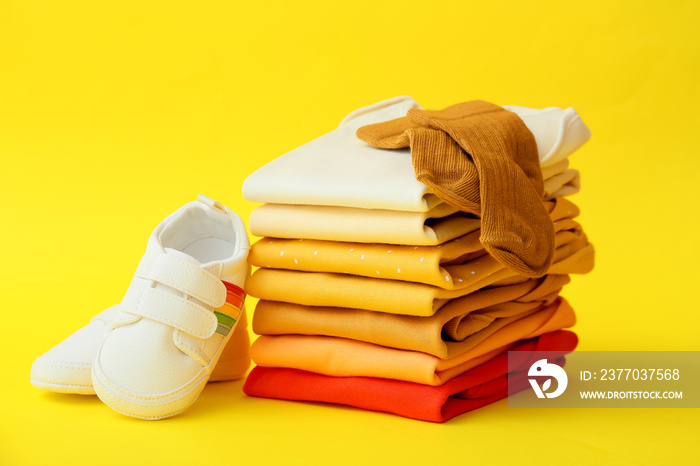 Set of baby accessories and shoes on color background