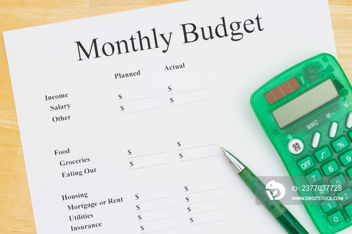 Cost of your monthly budget with cost for food focused with a calculator and pen