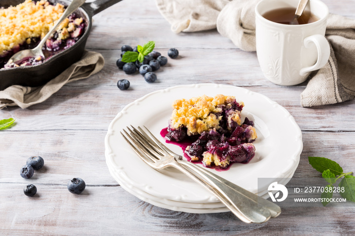 Coconut crumble on white plate with fresh apples and blueberry. Healthy food concept.