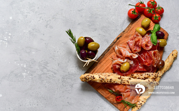 Traditional Italian appetizers antipasto : salami, bresaola, prosciutto parma, olives. Aperitif in Italy in Florence, Rome, aperitif in Milan. Two glasses of Prosecco and sticks of cereal bread