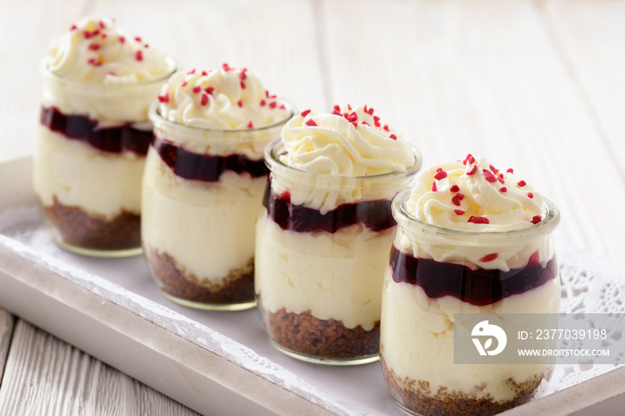 Cheesecake with cherry jelly in glass jars.