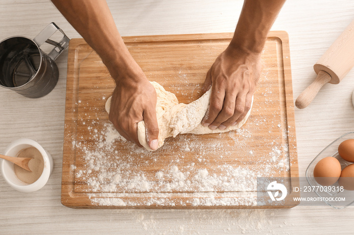 Man kneading dough on table