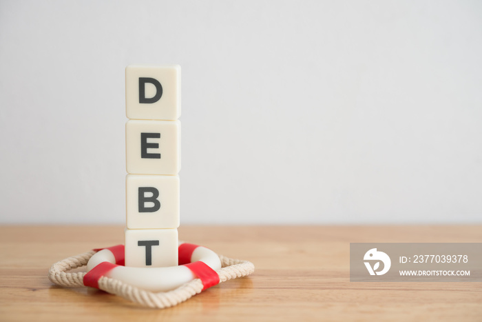 Debt protection insurance concept. Word DEBT is protected by lifebuoy on wooden white wall background copy space. Debt protection insurance can protect from unemployment, sickness, disability or died.