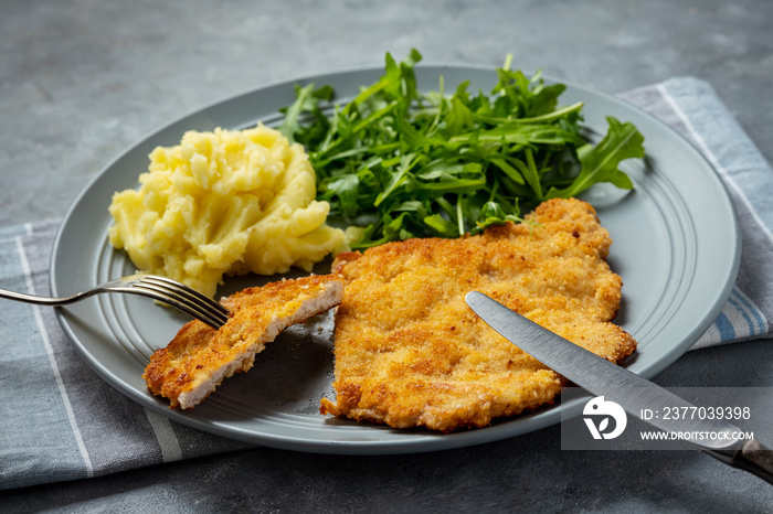 Chop pork cutlets , served with mashed potatoes and arugula.