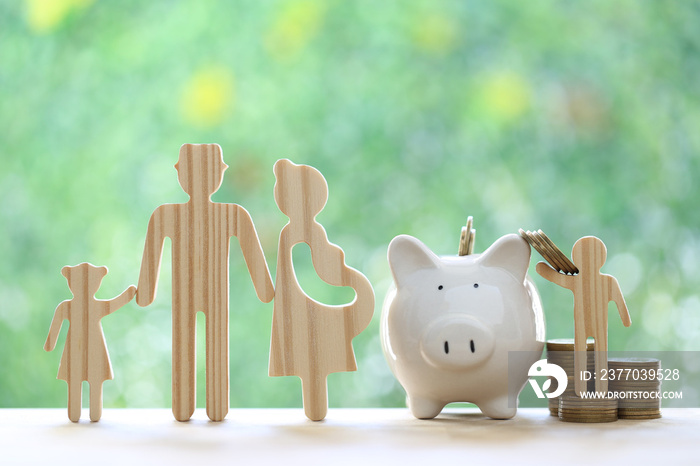 Model family with piggy bank and stack of coins money on natural green background,Save money for prepare in future and family finance concept