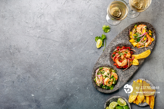 CEVICHE. Three colorful shrimps ceviche with mango, avocado and tomatoes. Latin American Mexican Peruvian Ecuadorian food. Served with white wine and banana chips