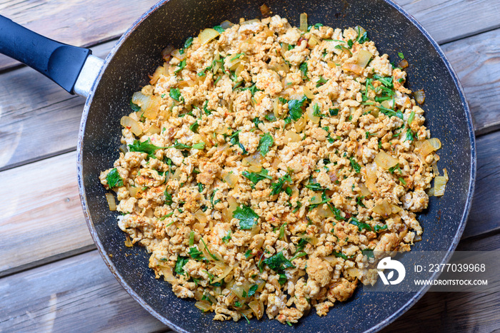 Preparing Ground meat. Chicken , Beef or Turkey Mince stir fry in frying pan on wood background.